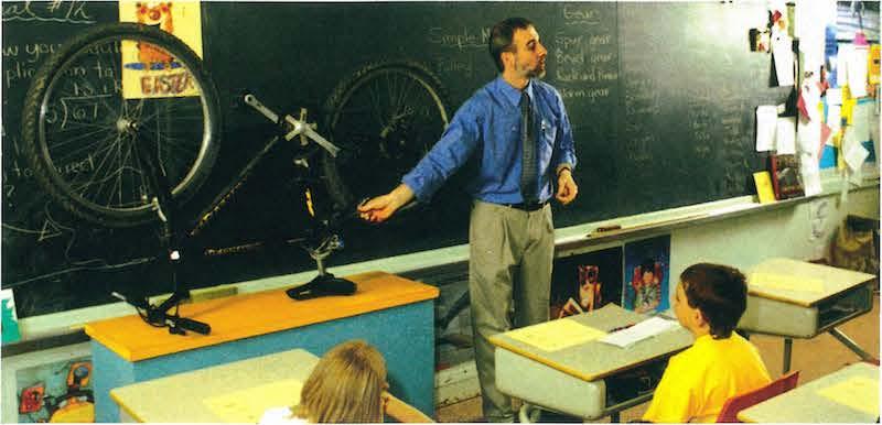 teacher in front of class showing bycilce