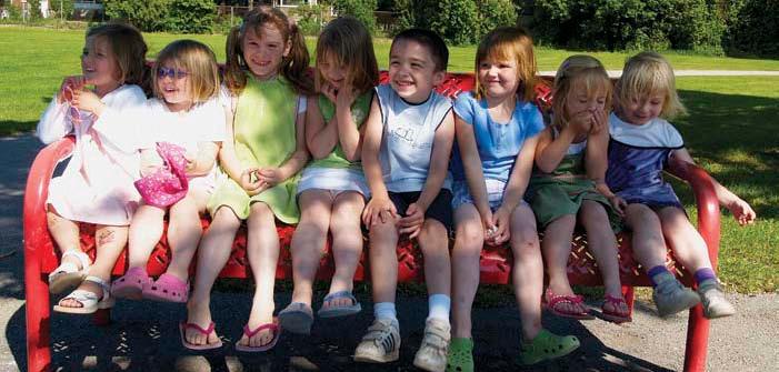 8 kindergarten students sitting on bench