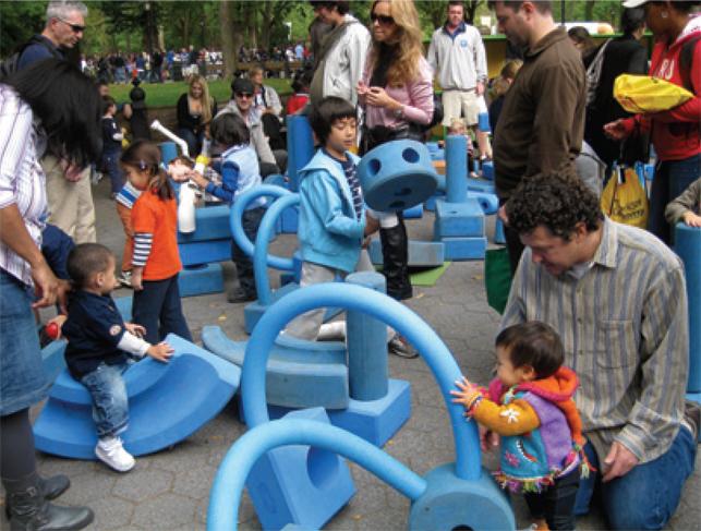 very young children playing in playground with adults