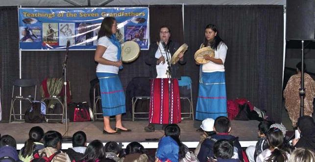 three women performing on stage with drums