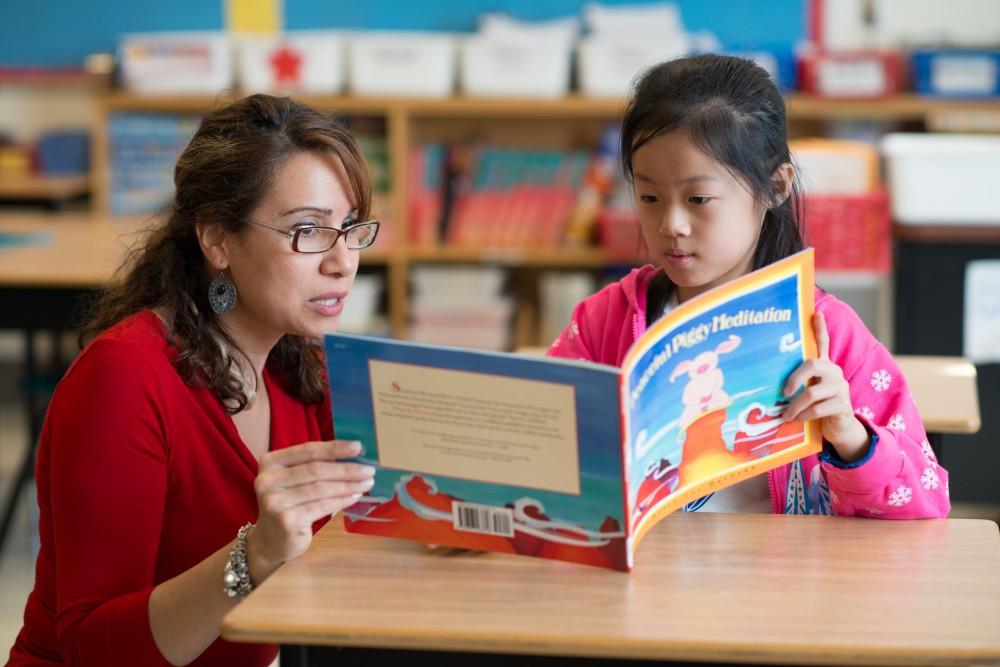 Teacher reading with elementary student