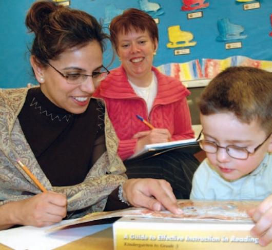 Teachers helping young student read
