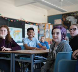 Students sitting at large desks in classroom