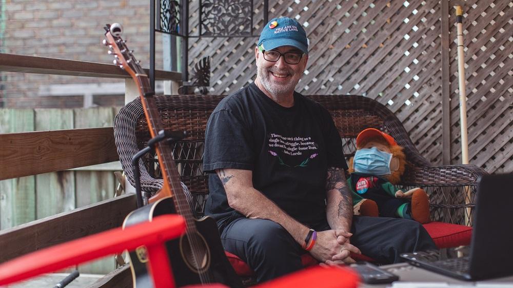 Gordon Nore on patio with guitar