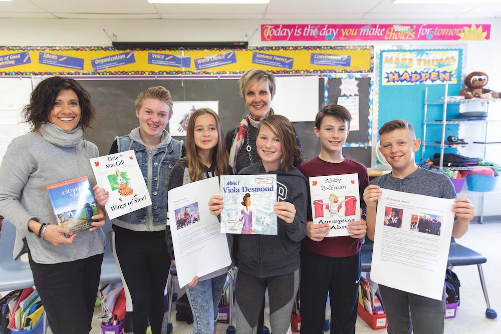 students and teachers holding books and articles