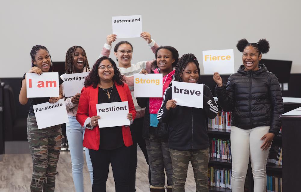 students holding inspirational signs