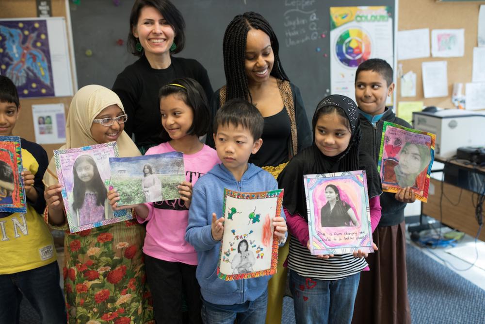Young students with teachers holding up feminism projects