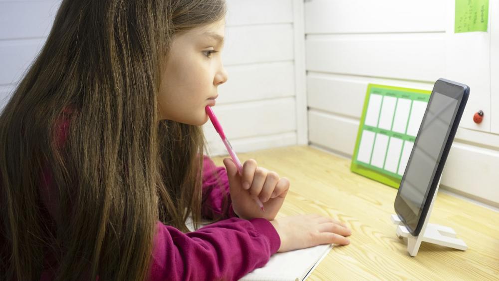 Young girl looking at tablet computer in classroom