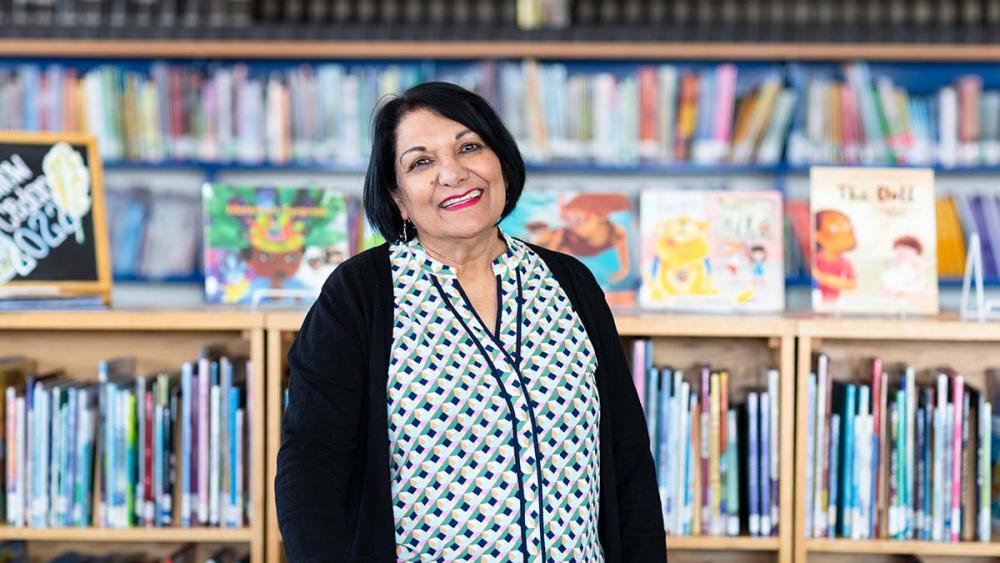 Shamim Murji standing in library of school