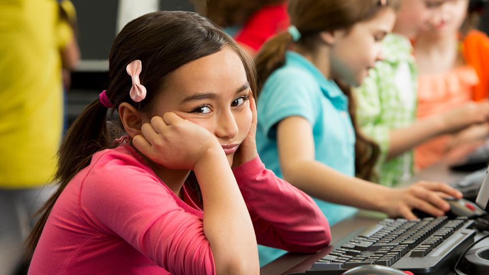 Young girl looking frustrated in classroom