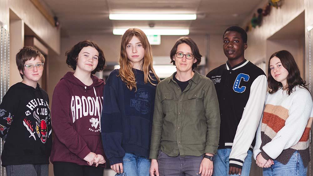 Diverse group of students standing in hallway of school