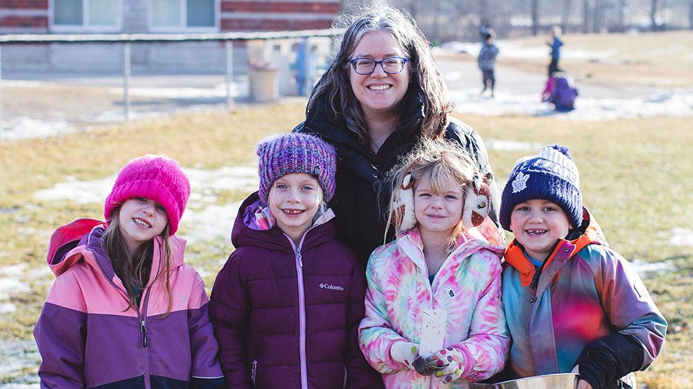 Christina Wilson posing with four children from class in a park