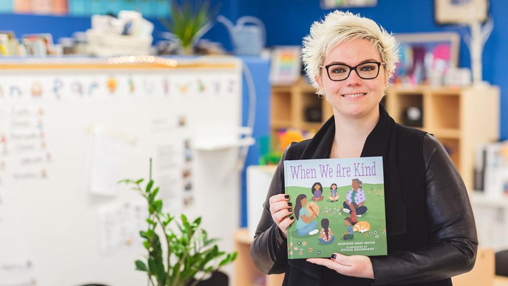 Michelle McKay posing with indigenous focused book