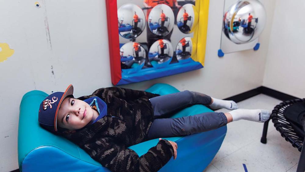Student laying on chair in sensory room