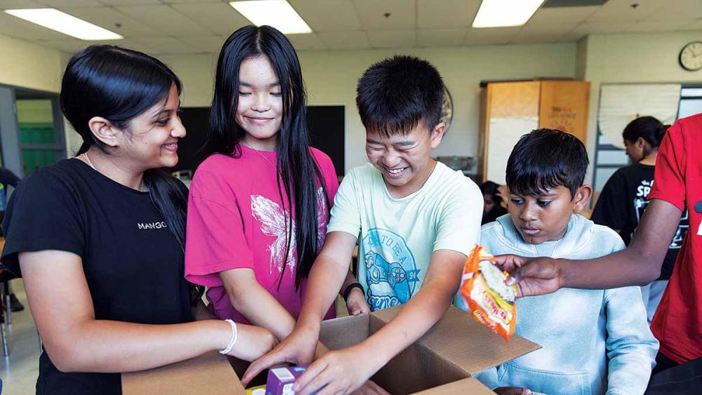 Neema Patel and students filling box with food