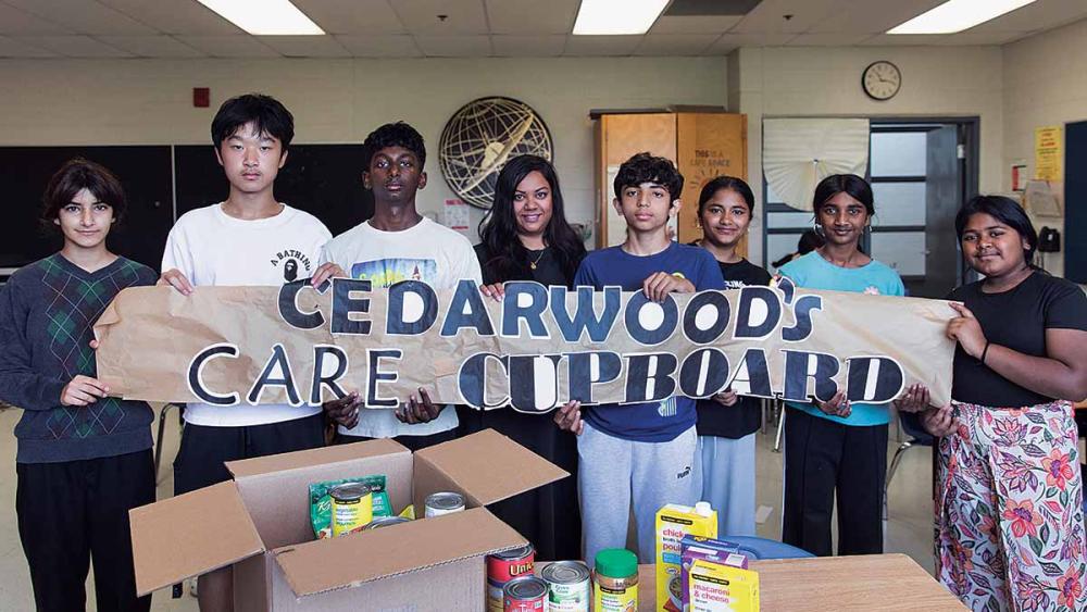 Students holding up care cupboard sign