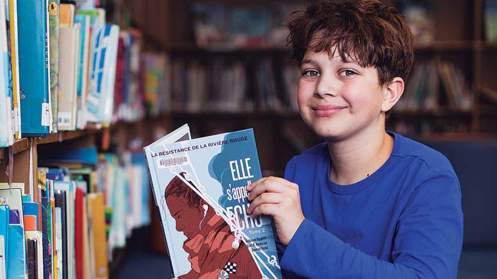 White male student picking a book to read in the library