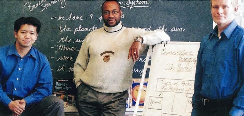 3 male teachers standing in classroom