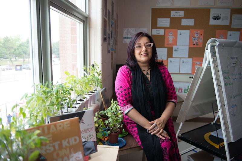 Zaiba Beg standing in classroom next to window and plants