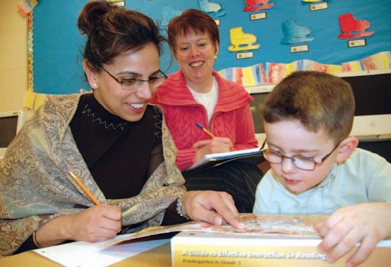 Teachers helping young student read