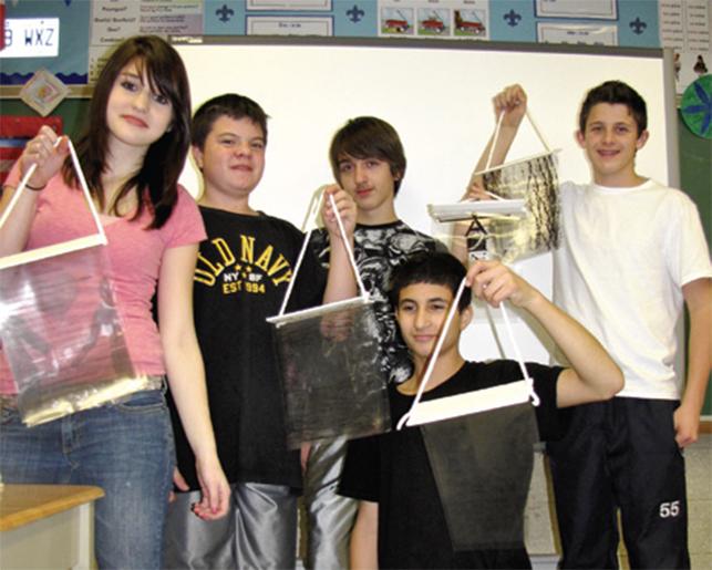 students posing with their art projects