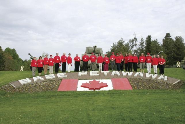 ETFO members wearing red posing next to Base Petawawa sign