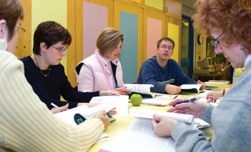 etfo members sitting around table discussing content in textbooks