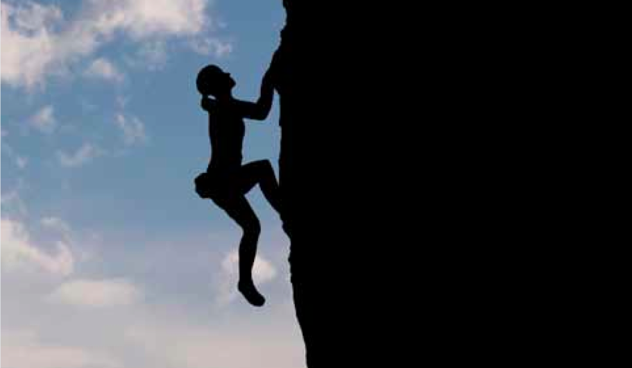 Silhouette of woman climbing cliff