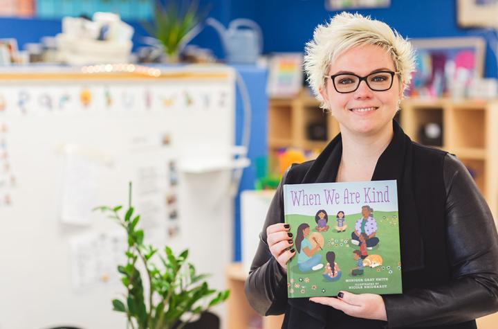 Michelle McKay posing with indigenous focused book