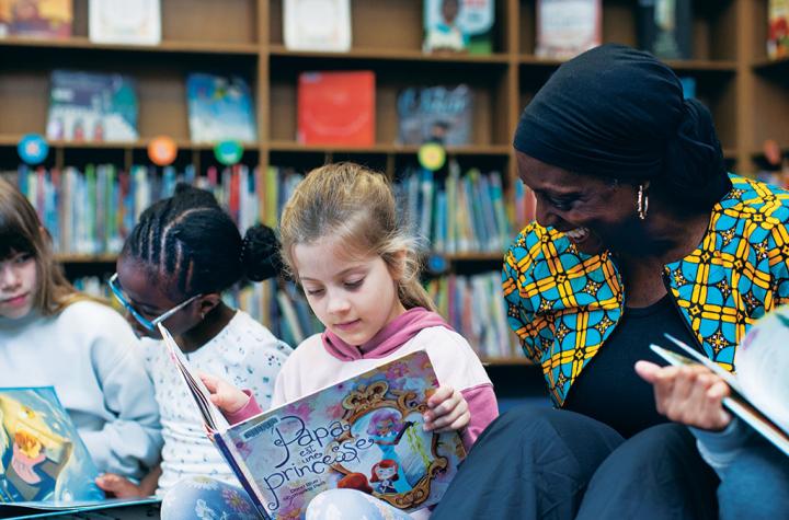 Gloria Ladson-Billings reading books with children in library