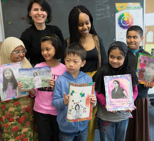 Young students with teachers holding up feminism projects