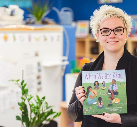 Michelle McKay posing with indigenous focused book