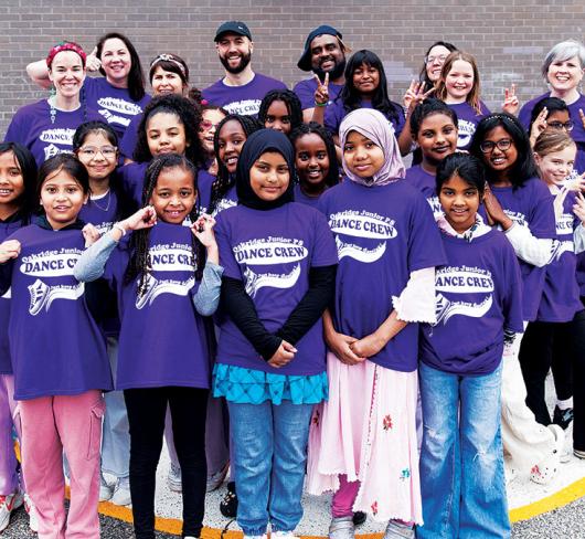 Dance Crew students and teachers posing outside of school