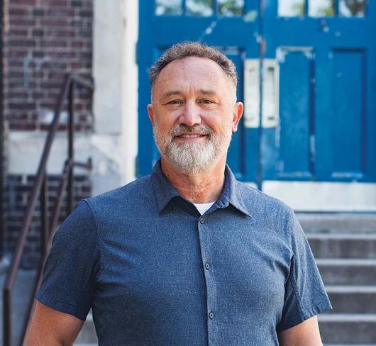 David Mastin posing outside of a school