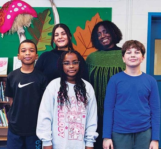 Karen Devonish-Mazzota And Leanna Bornstein posing with students in the library