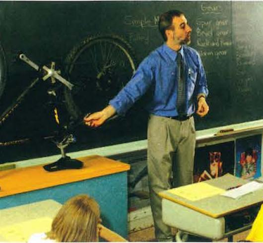 teacher in front of class showing bycilce
