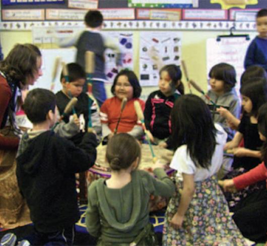 kindergarten teacher sitting in circle with students