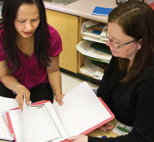two teachers reading a report
