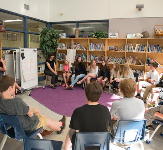 Students sitting in a circle of chairs