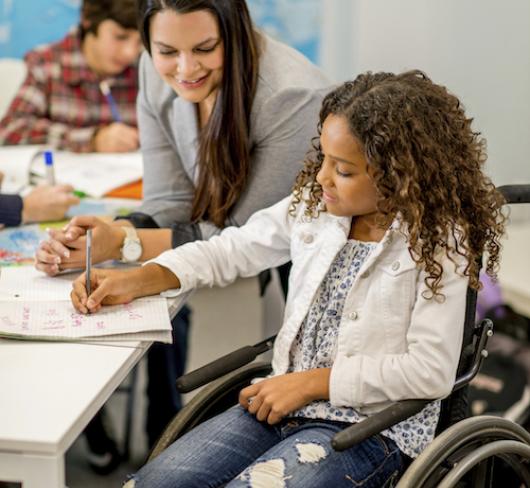 Teacher working with student in wheelchair