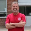 Sam Hammond posing outside of school in red ETFO t-shirt